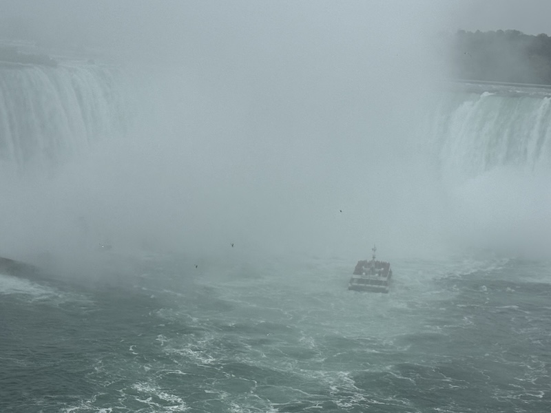 Mist and spray obscuring a boat tour navigating close to Niagara Falls
